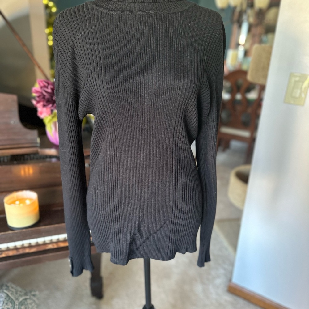 Black turtle neck sweater with button trim on sleeves.
